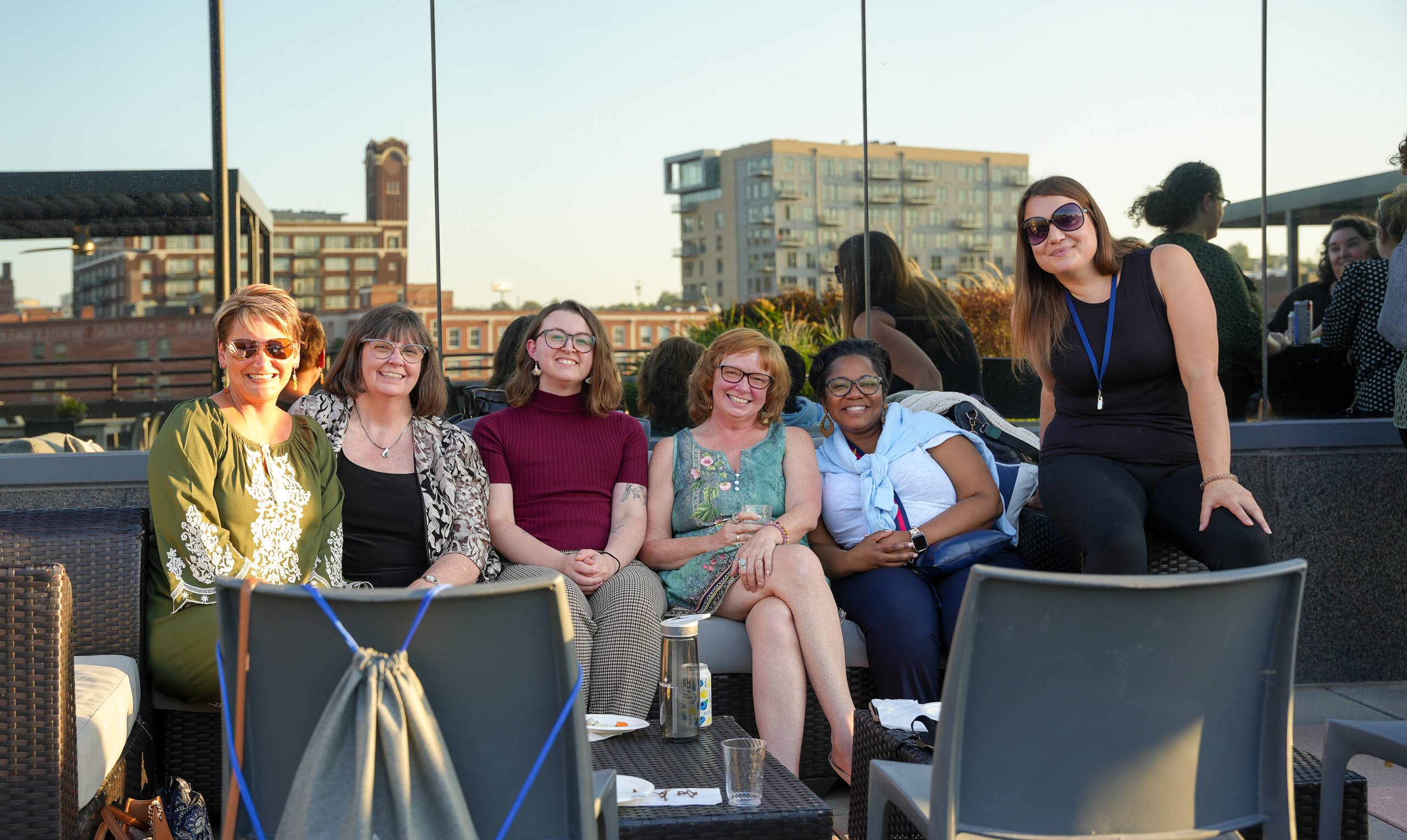 A group of EEO Consulting clients and colleagues seated together at a rooftop gathering